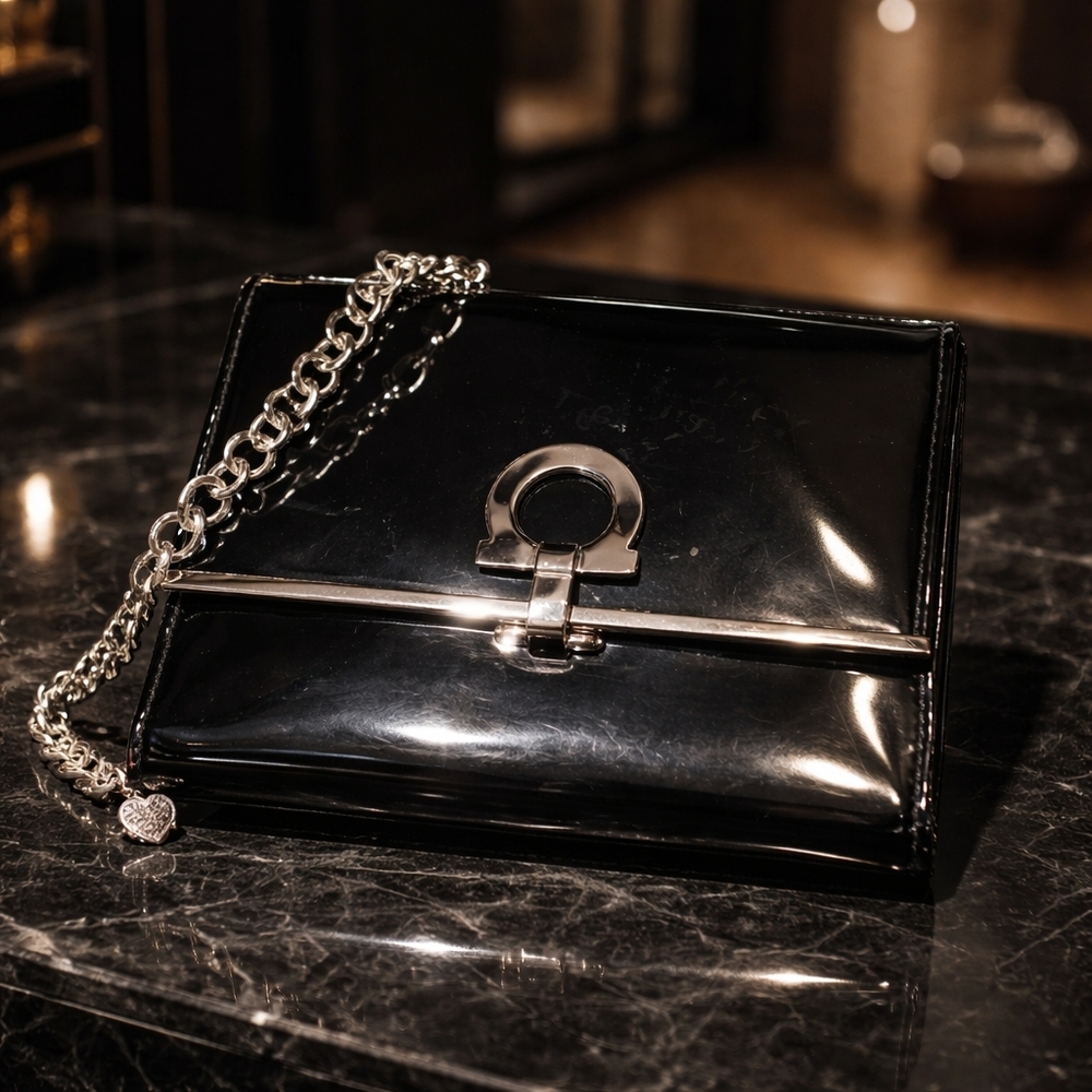 Salvatore Ferragamo patent leather wallet with a Gancini clasp and a chain strap
